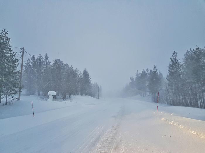 Lumi tuiskuaa tiellä.