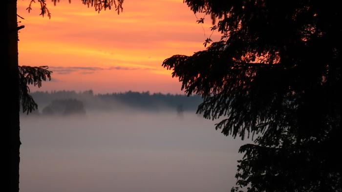 Sumua Auringonlaskun oranssi taivas ja sadekuurojen jälkeistä sumua yöllä 11.–12. kesäkuuta 2022 Utajärvellä.
