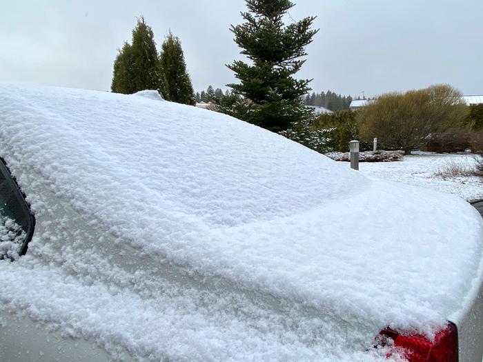 Lumi kuorrutti autoa Tuusulassa 14. huhtikuuta 2020.