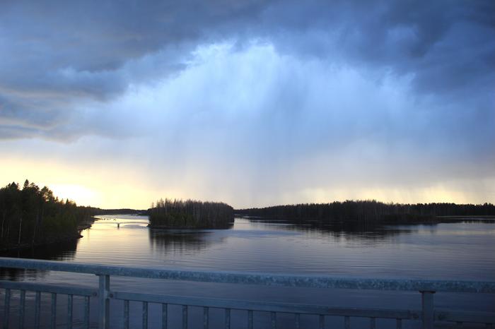 Toukokuinen sadekuuro illalla auringon laskiessa Oulujoella.