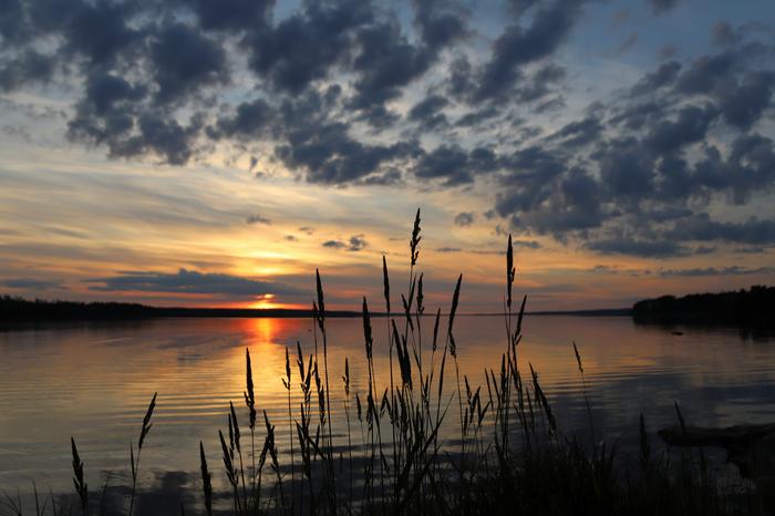 Aurinko laskee pilvien takana.