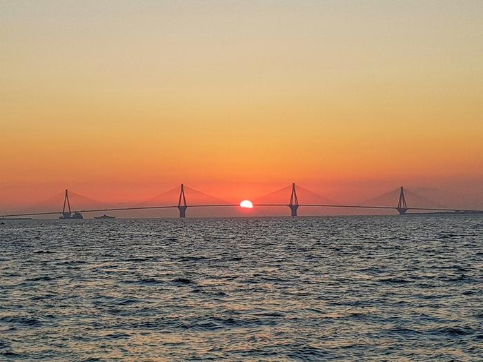 Aurinko laskee Välimeren taakse Kreikan rannikkoseudulla. 