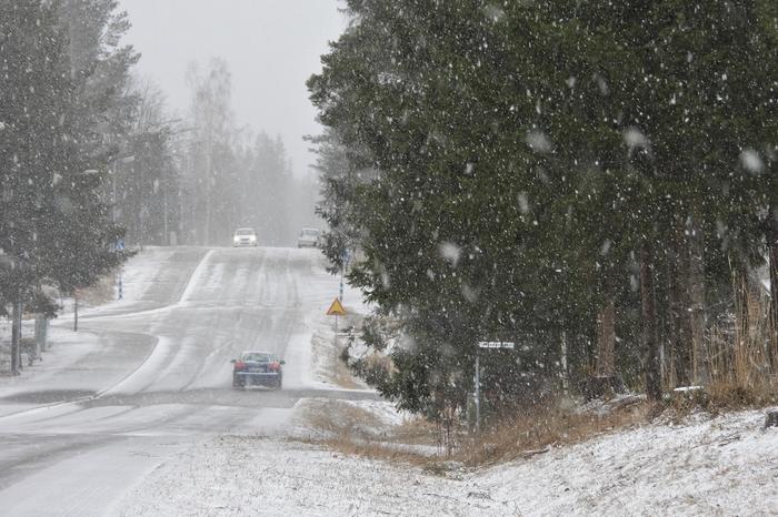 Liikennettä keväisessä lumisateessa.