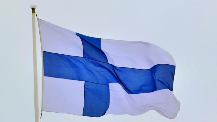 Suomen lippu liehuu tuulisessa säässä.