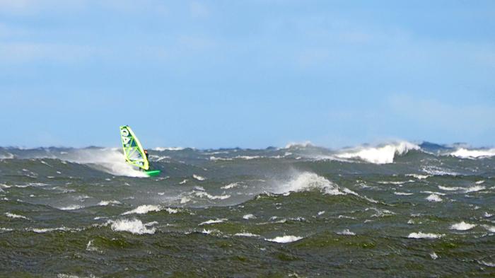 Myrskyä Tuulinen sää saa surffaajat merelle.