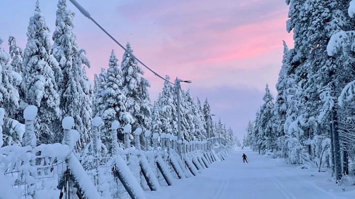 Matalalta paistava aurinko saa valon siroamaan ilmakehässä kauniisti maalaten taivaan punertavilla sävyillä.