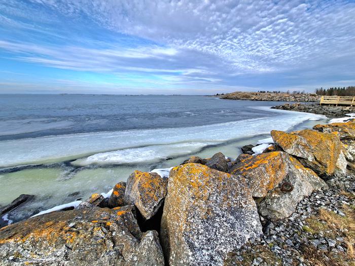 Keväinen merenranta Jää tummenee haurastuessaan kevätauringossa.
