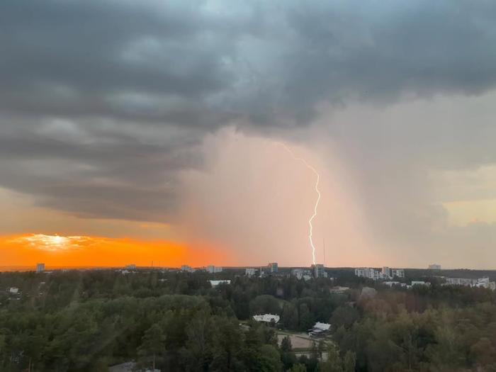 Salama iskee ukkoskuurossa auringon laskiessa.